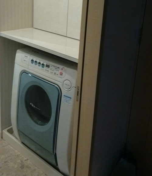 洗面所にはコンパクトな収納と、下部にはドラム式洗濯機が設置され、ミニマムなスペースでも使いやすい。
