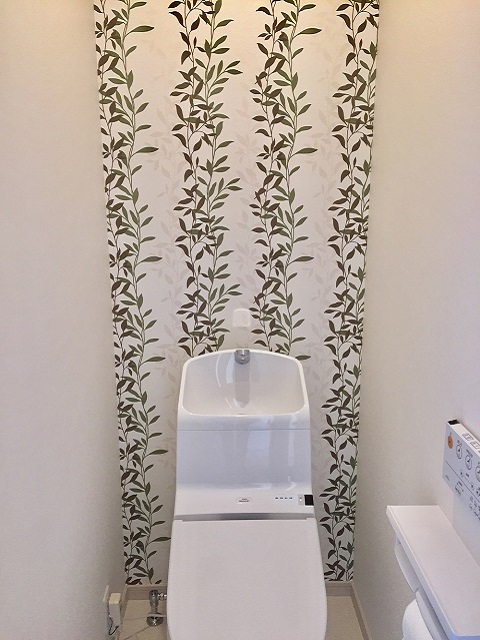 2階のトイレは明るい雰囲気。背面の壁に貼ってあるボタニカル柄のアクセントクロスがお気に入りだとか。
