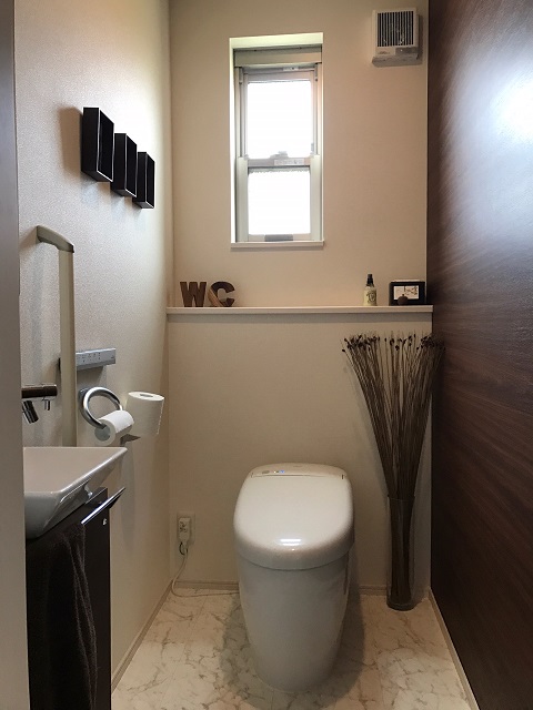 トイレは、背面に小物を置けるスペースを作ったり、手洗い器を追加したり、白と茶の壁紙を左右で貼り分けたりと手を加え、デザインにも使い勝手にもこだわっている。